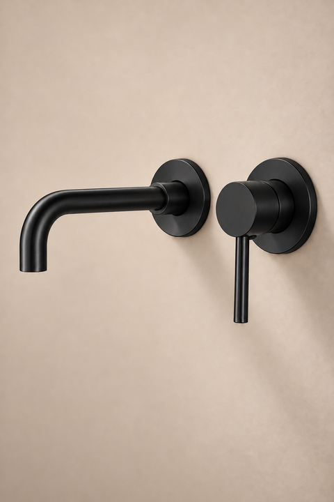 Mitigeur lavabo encastré mural Ysel noir mat Azéo — bec courbé et levier sur rosaces rondes, vue de trois quarts sur un mur beige